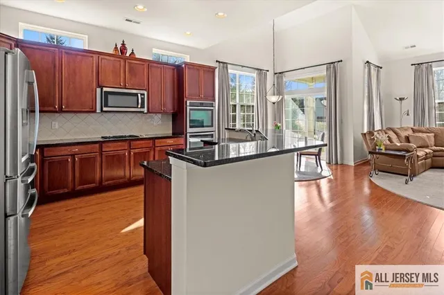 a kitchen with granite countertop stainless steel appliances and wooden cabinets