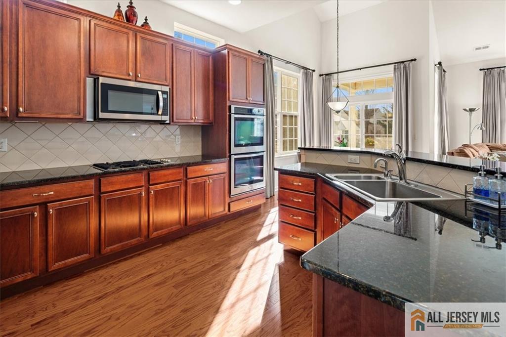 9 Bellingham Drive Kendall Park, NJ 08824 - Photo 13 of 65 a kitchen with stainless steel appliances granite countertop a stove a sink and a microwave