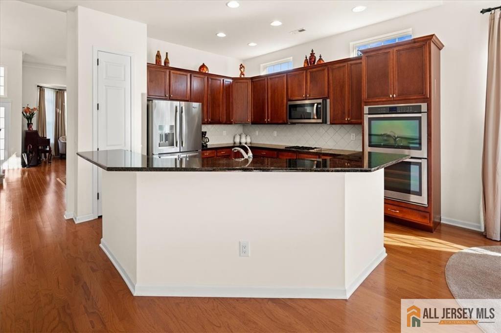 9 Bellingham Drive Kendall Park, NJ 08824 - Photo 16 of 65 a kitchen with stainless steel appliances granite countertop a refrigerator a stove a sink and a microwave