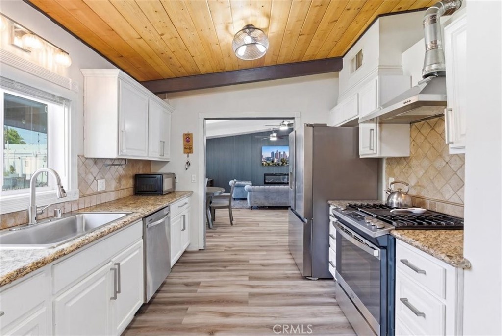 7959 Bothwell Road Reseda, CA 91335 - Photo 14 of 60 a kitchen with granite countertop a sink stove and cabinets
