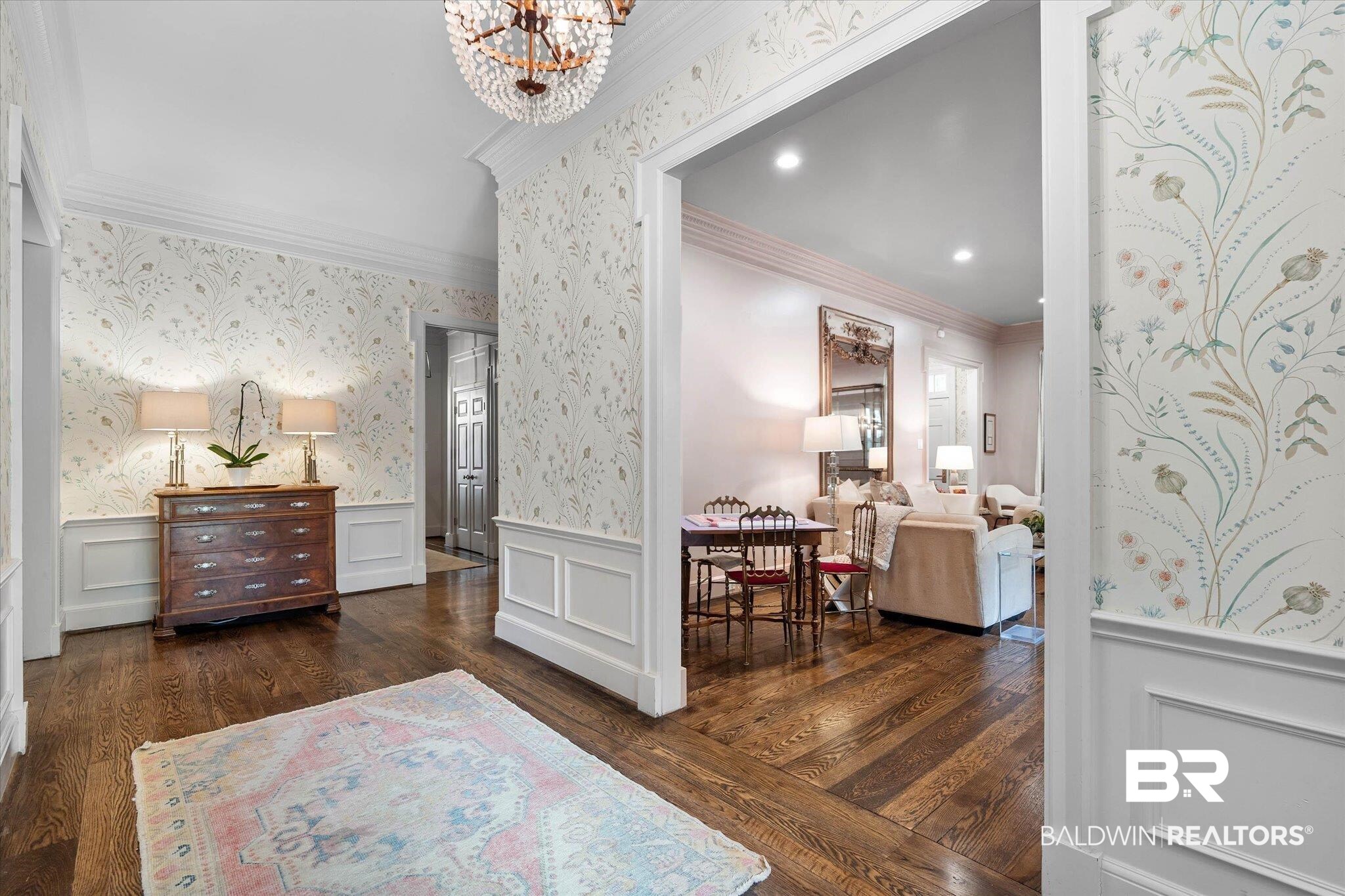 3908 Yester Place Mobile, AL 36608 - Photo 6 of 45 Hardwood flooring with a distinctive chevron pattern, white crown molding, and decorative wainscoting