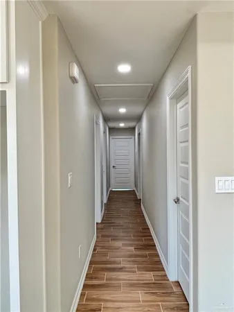 a view of a hallway with wooden floor