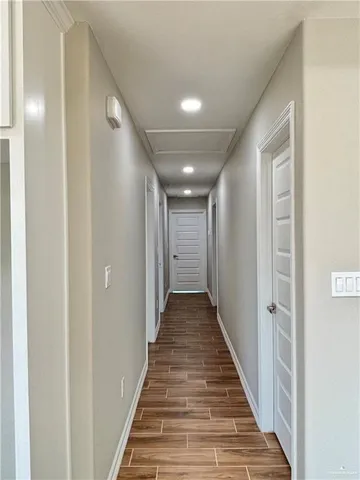 a view of a hallway with wooden floor