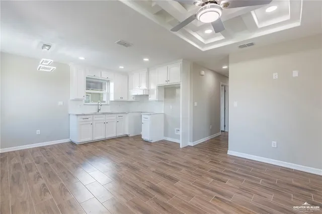 a view of kitchen with granite countertop cabinets and wooden floor