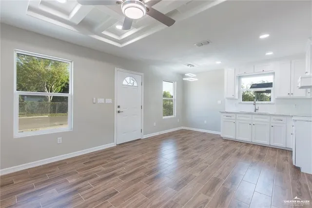 a view of a kitchen and a sink window wooden floor