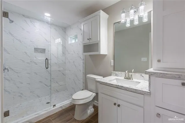 a bathroom with a sink a toilet and shower