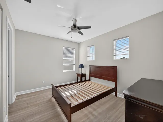 a view of a white house with a yard and potted plants