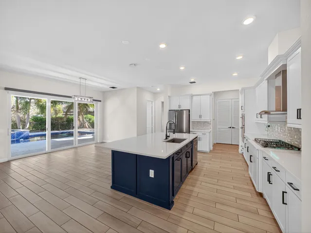 a view of an empty room with a window and a kitchen