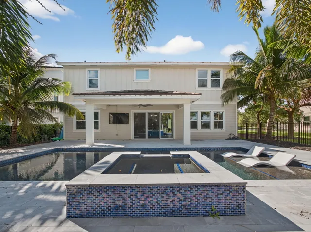 a living room with furniture a fireplace and large windows
