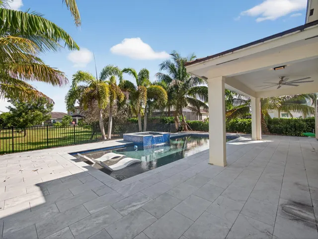 a living room with patio furniture and a floor to ceiling window