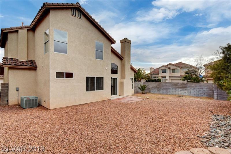 2647 Ridgewater Circle Henderson, NV 89074 - Photo 23 of 26 A spacious backyard area showcases low-maintenance landscaping and concrete block fencing.