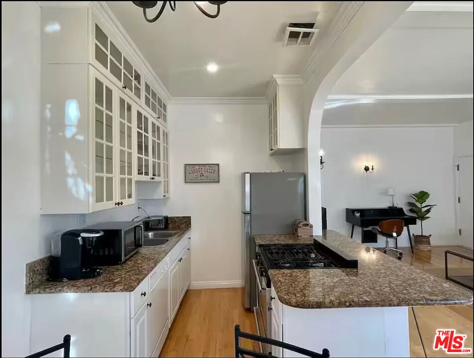 854 4th Street, Unit C Santa Monica, CA 90403 - Photo 5 of 12 a kitchen with stainless steel appliances granite countertop a sink stove and refrigerator