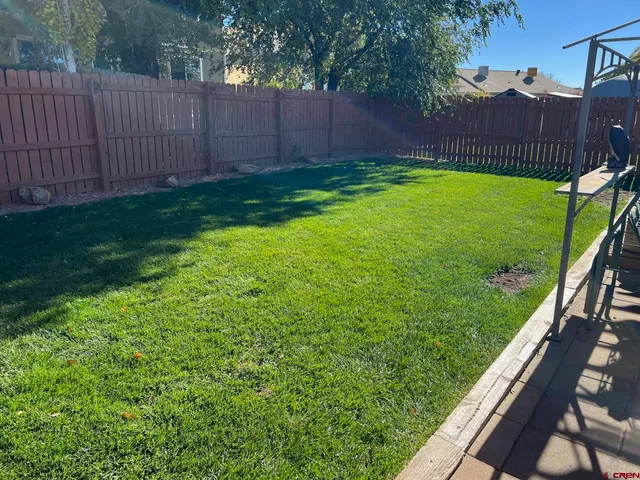 a view of a backyard with wooden fence