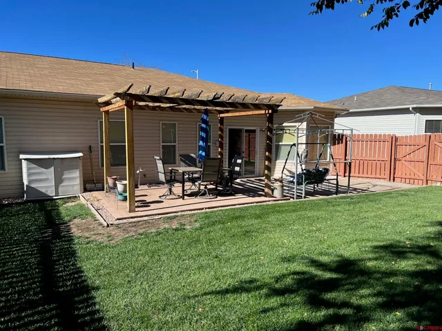 a view of a backyard with table and chairs potted plants and a chair