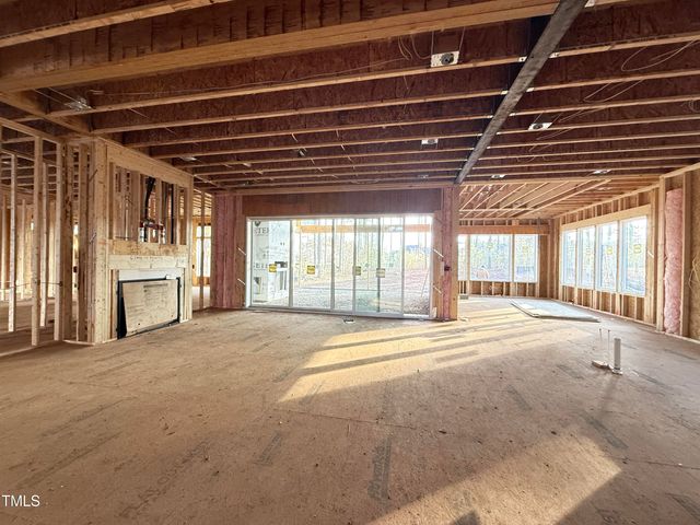 a view of an empty room with wooden floor and next to a window