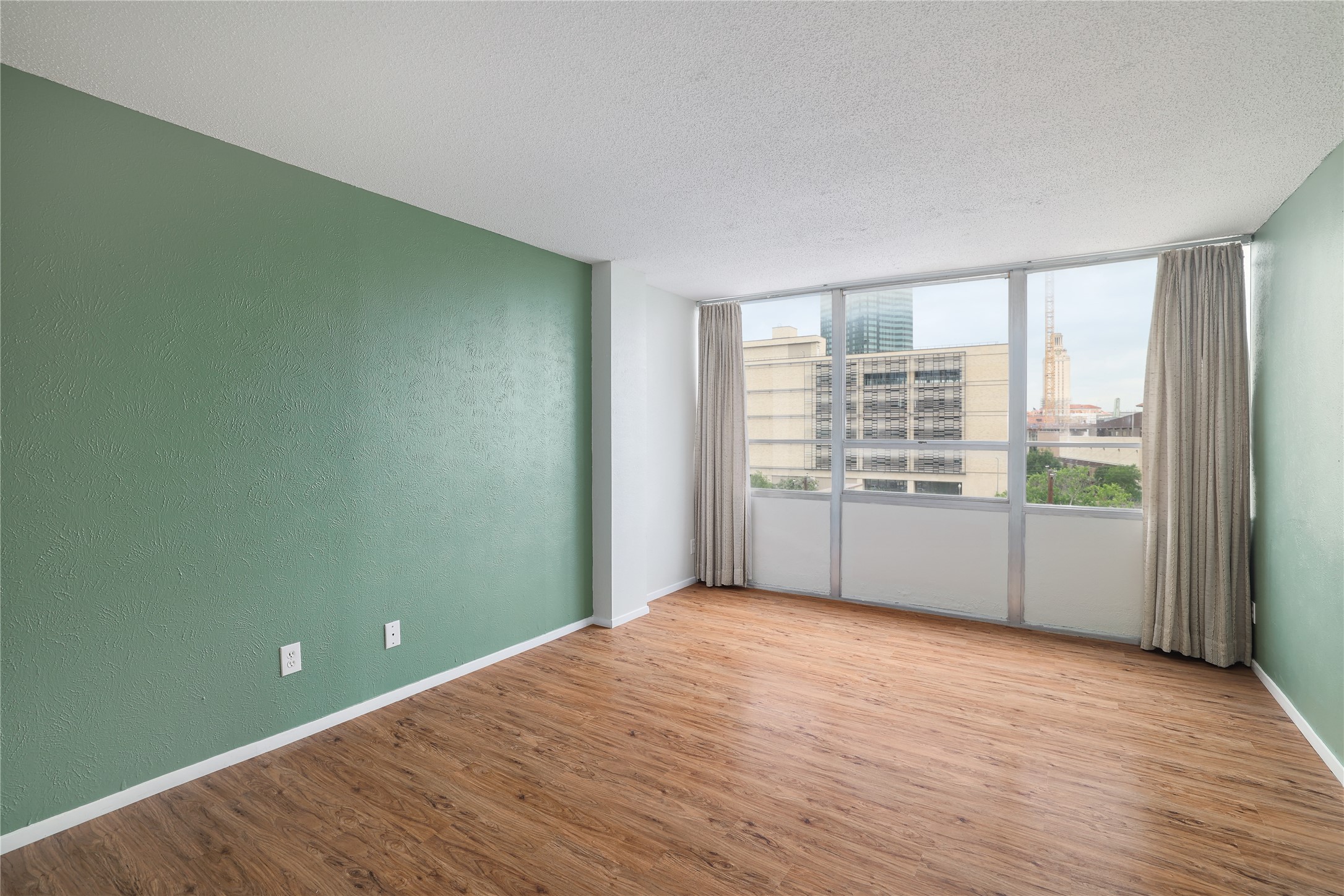 1800 Lavaca Street, Unit A508 Austin, TX 78701 - Photo 20 of 25 Second bedroom features laminate flooring, natural light, muted green and neutral colors and UT Campus views.