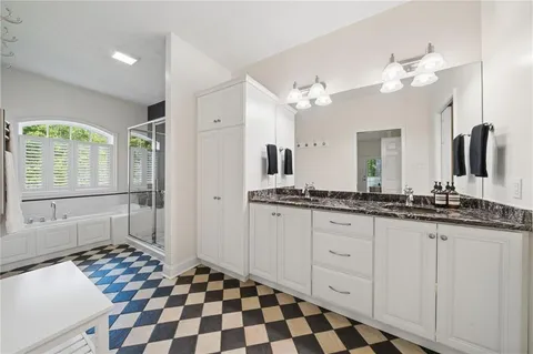 a spacious bathroom with a granite countertop sink mirror and a bathtub