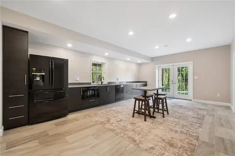 a kitchen with a dining table chairs and refrigerator