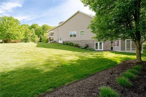 a view of a house with a big yard and large trees