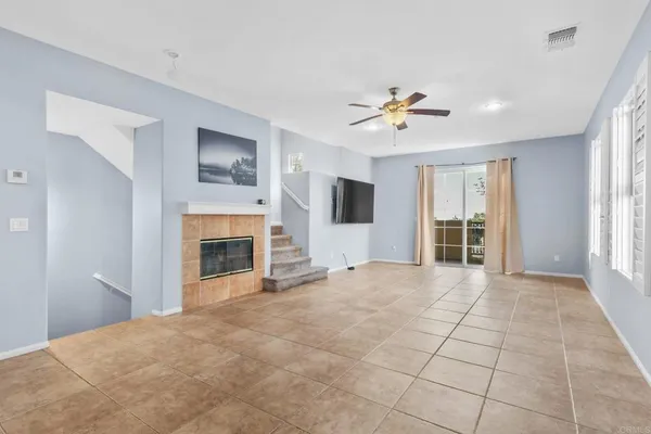 a view of an empty room with a fireplace and a window