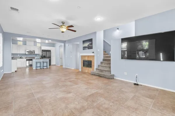 a view of a livingroom with furniture a flat screen tv and kitchen view