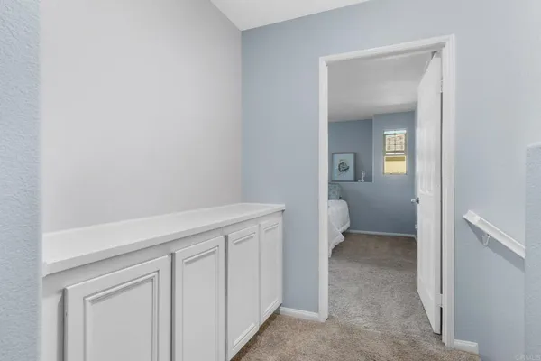 a hallway with white cabinets