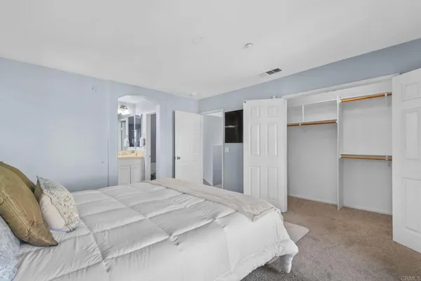 a bedroom with a large bed and a painting on the wall