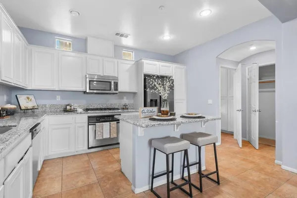 a kitchen with kitchen island granite countertop wooden cabinets and a stove