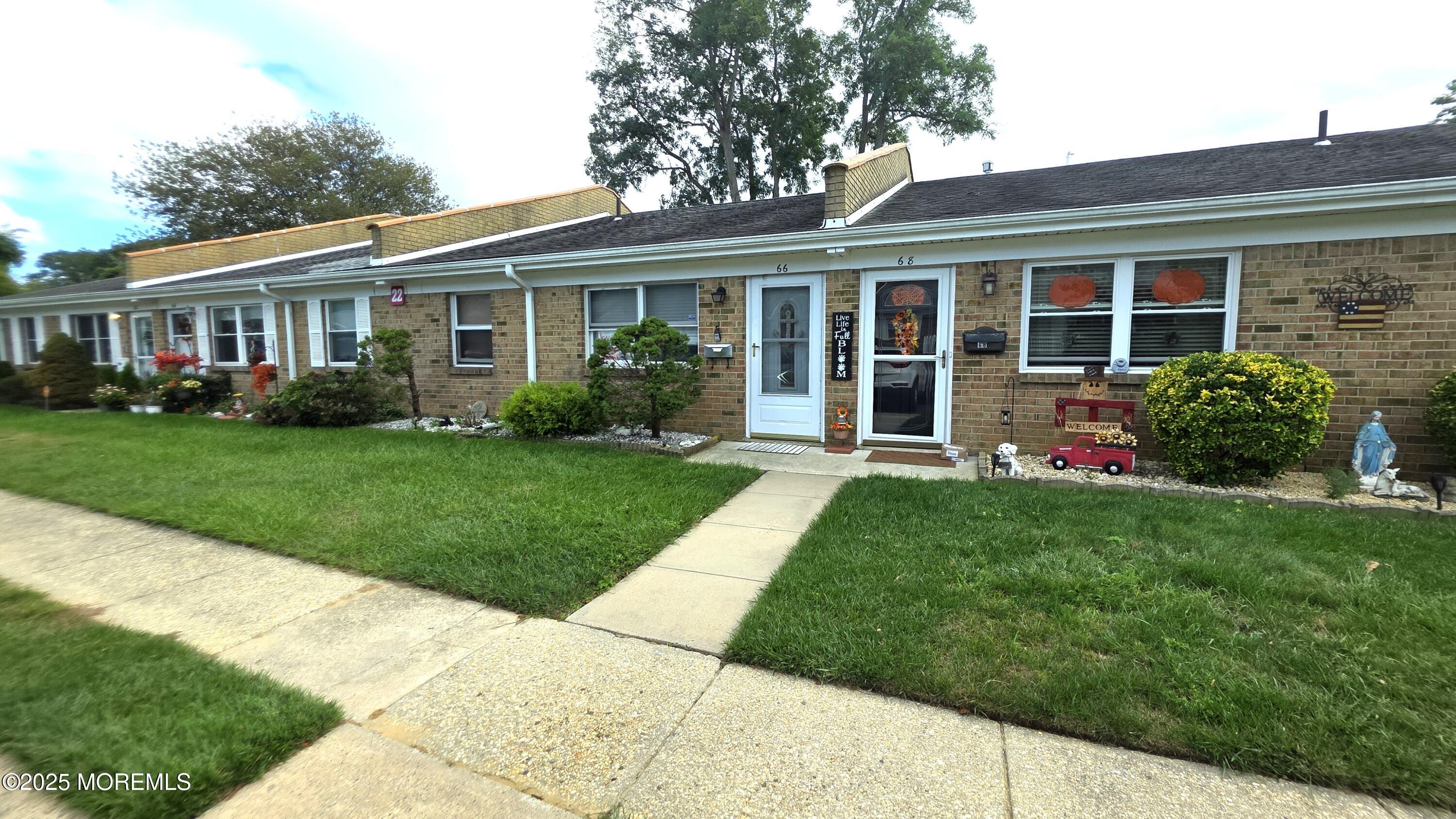 66 Breeze Court, Unit 97 Brick, NJ 08724 - Photo 1 of 18 a front view of a house with a yard and porch