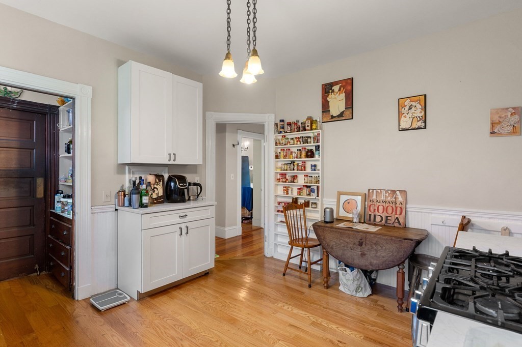 10-12 Castlerock Street, Unit 2 Boston, MA 02125 - Photo 8 of 24 a kitchen with stainless steel appliances a table and chairs in it