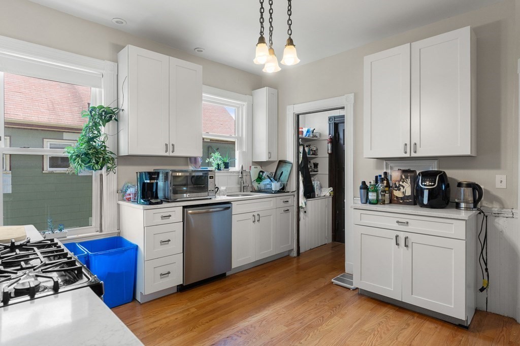 10-12 Castlerock Street, Unit 2 Boston, MA 02125 - Photo 9 of 24 a kitchen with stainless steel appliances granite countertop a stove a sink dishwasher and a refrigerator with wooden floor