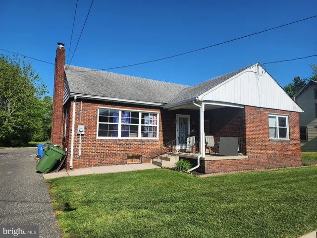 a backyard of a house with table and chairs potted plants and wooden fence