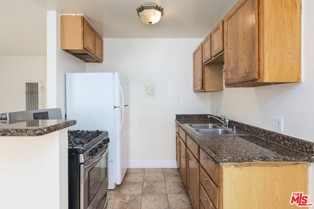 1920 North H Street, Unit 246 Oxnard, CA 93036 - Photo 11 of 31 a kitchen with stainless steel appliances granite countertop a sink stove and refrigerator