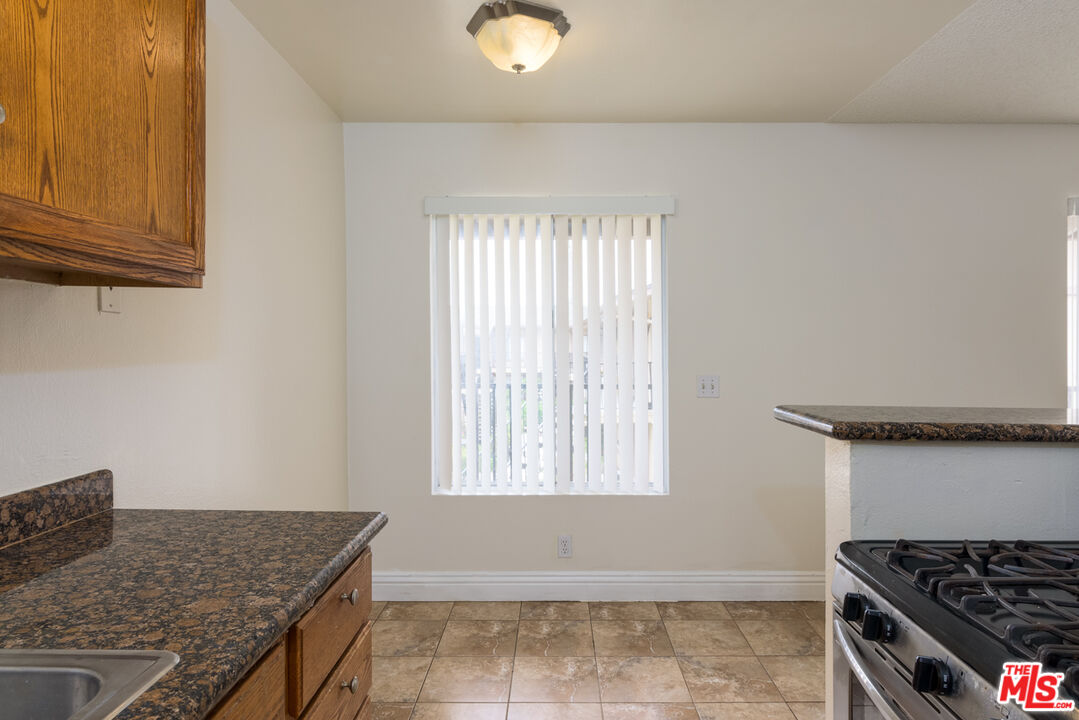1920 North H Street, Unit 246 Oxnard, CA 93036 - Photo 10 of 31 a kitchen with granite countertop a stove and a sink