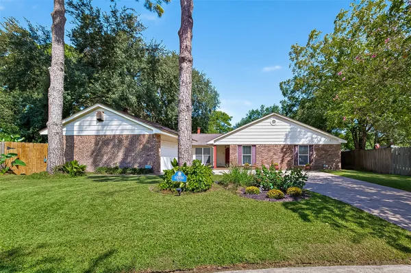 a front view of a house with a yard and potted plants