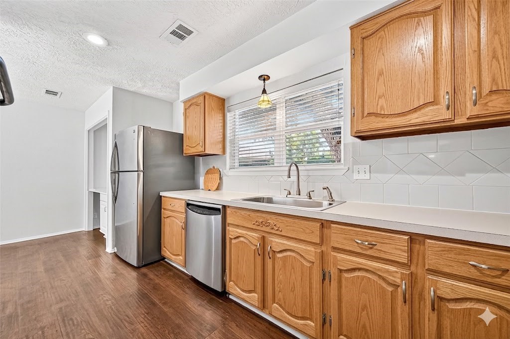 12910 Aste Lane Houston, TX 77065 - Photo 13 of 37 a kitchen with stainless steel appliances granite countertop a refrigerator and a sink
