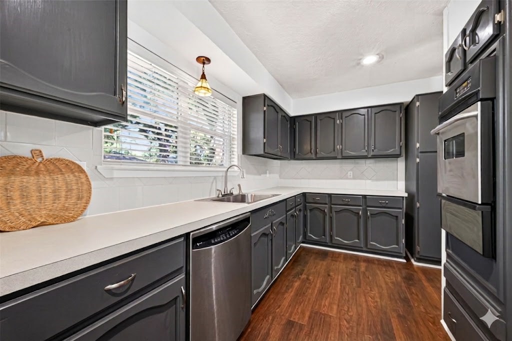 12910 Aste Lane Houston, TX 77065 - Photo 15 of 37 a kitchen with granite countertop stainless steel appliances a sink stove top oven and cabinets