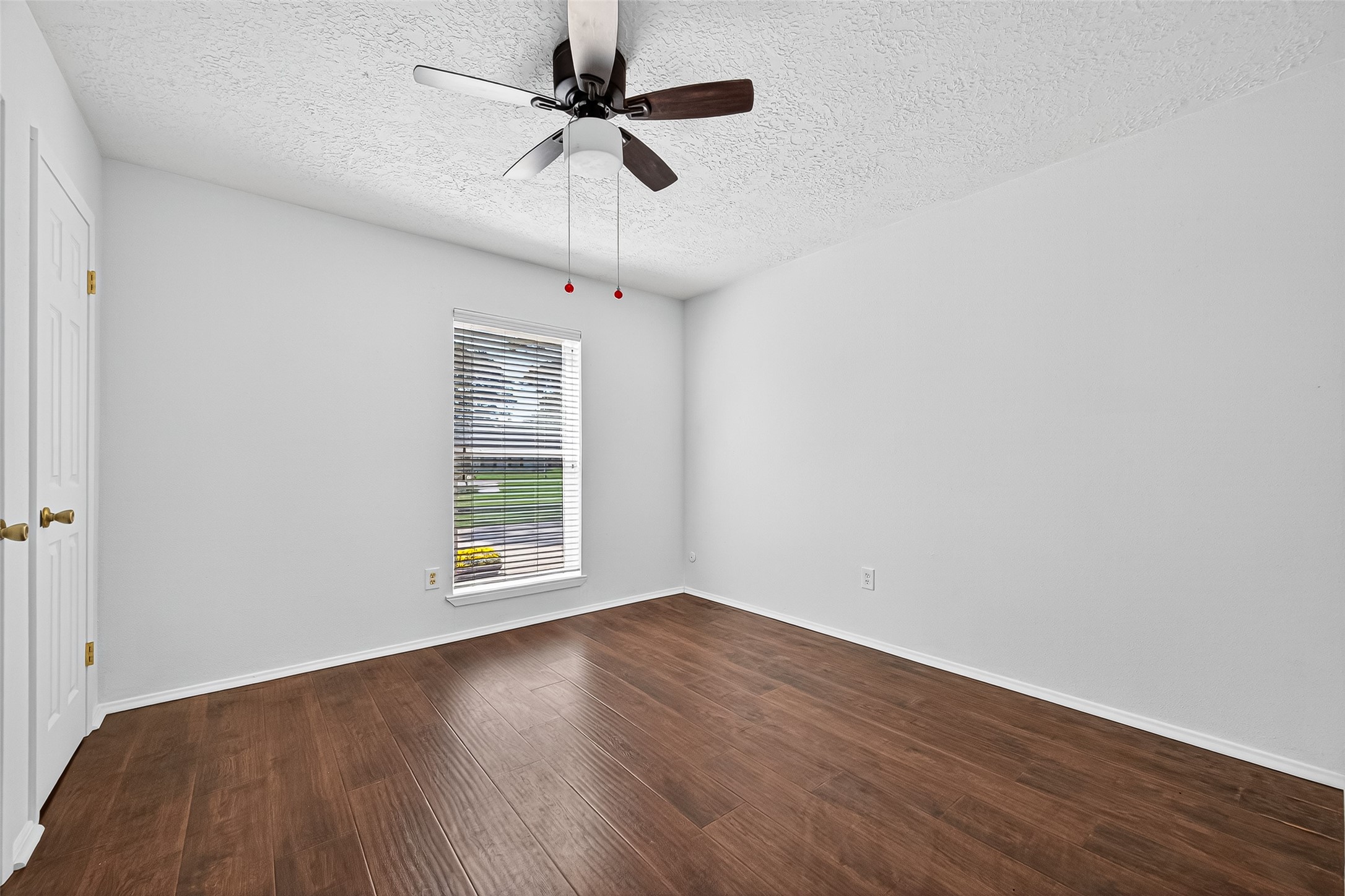 12910 Aste Lane Houston, TX 77065 - Photo 21 of 37 an empty room with wooden floor ceiling fan and windows