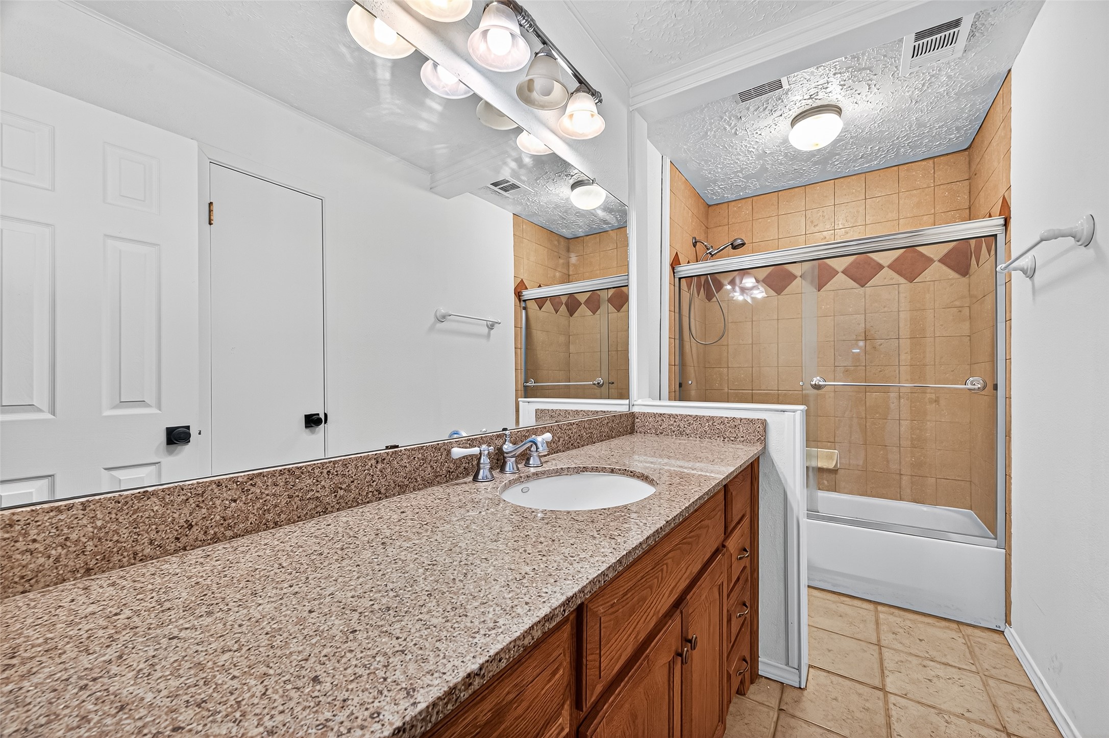 12910 Aste Lane Houston, TX 77065 - Photo 23 of 37 a bathroom with a granite countertop sink a mirror and a bathtub