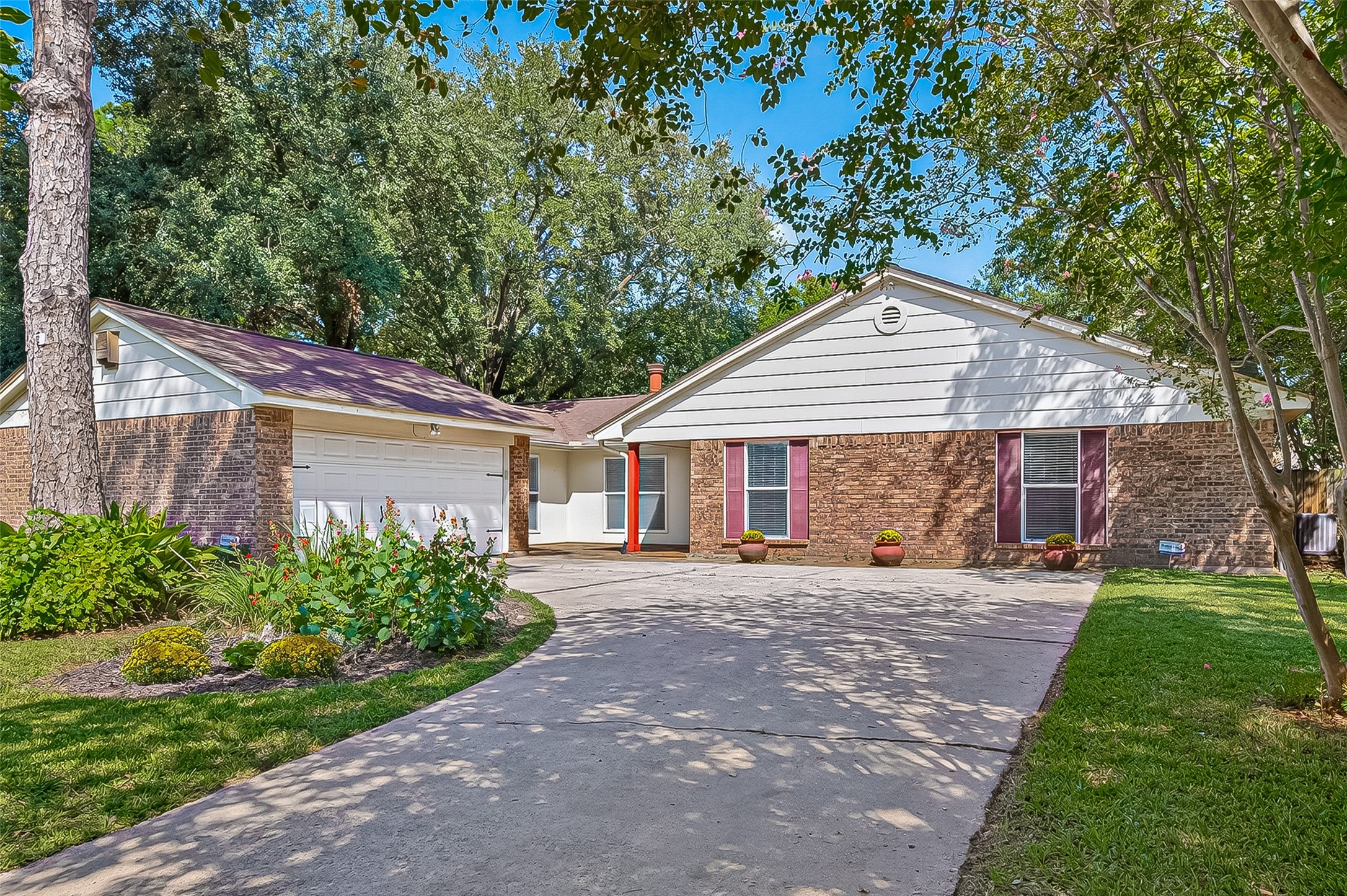 12910 Aste Lane Houston, TX 77065 - Photo 3 of 37 a front view of a house with a garden and trees