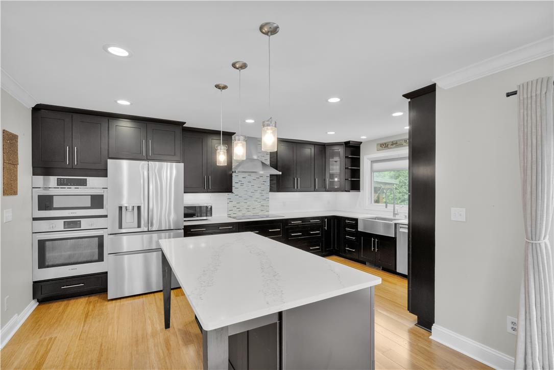 3396 Darien Road Bethlehem, PA 18020 - Photo 16 of 44 Culinary delights await in this modern kitchen with sleek dark cabinetry and gleaming stainless steel appliances.