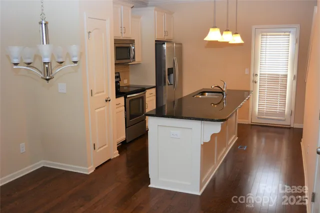 a kitchen with sink refrigerator and microwave