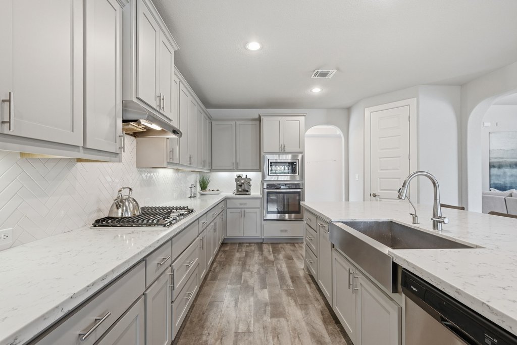191 Tabago Court Austin, TX 78737 - Photo 12 of 40 a kitchen with stainless steel appliances granite countertop a sink stove and cabinets