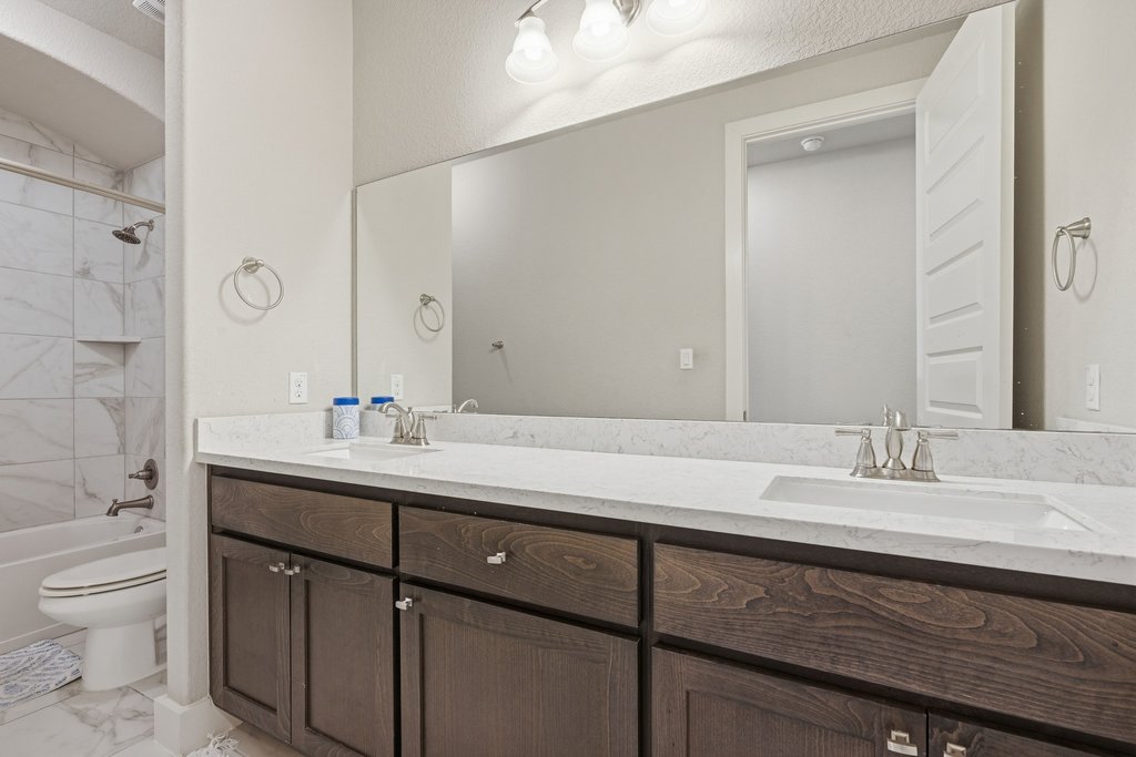 191 Tabago Court Austin, TX 78737 - Photo 22 of 40 a bathroom with a granite countertop sink a toilet and a mirror