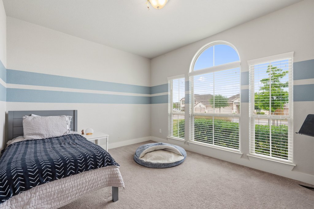 191 Tabago Court Austin, TX 78737 - Photo 24 of 40 a bedroom with a bed and a large window