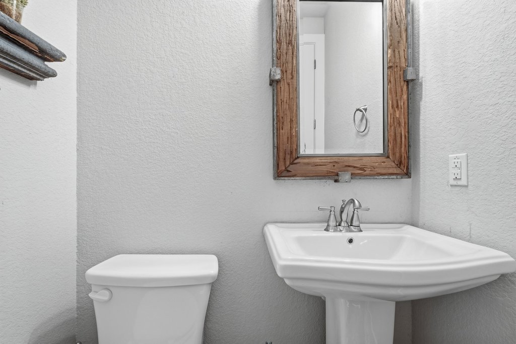 191 Tabago Court Austin, TX 78737 - Photo 31 of 40 a bathroom with a sink a toilet and mirror
