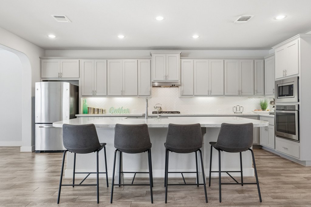 191 Tabago Court Austin, TX 78737 - Photo 8 of 40 a kitchen with a dining table chairs refrigerator and cabinets