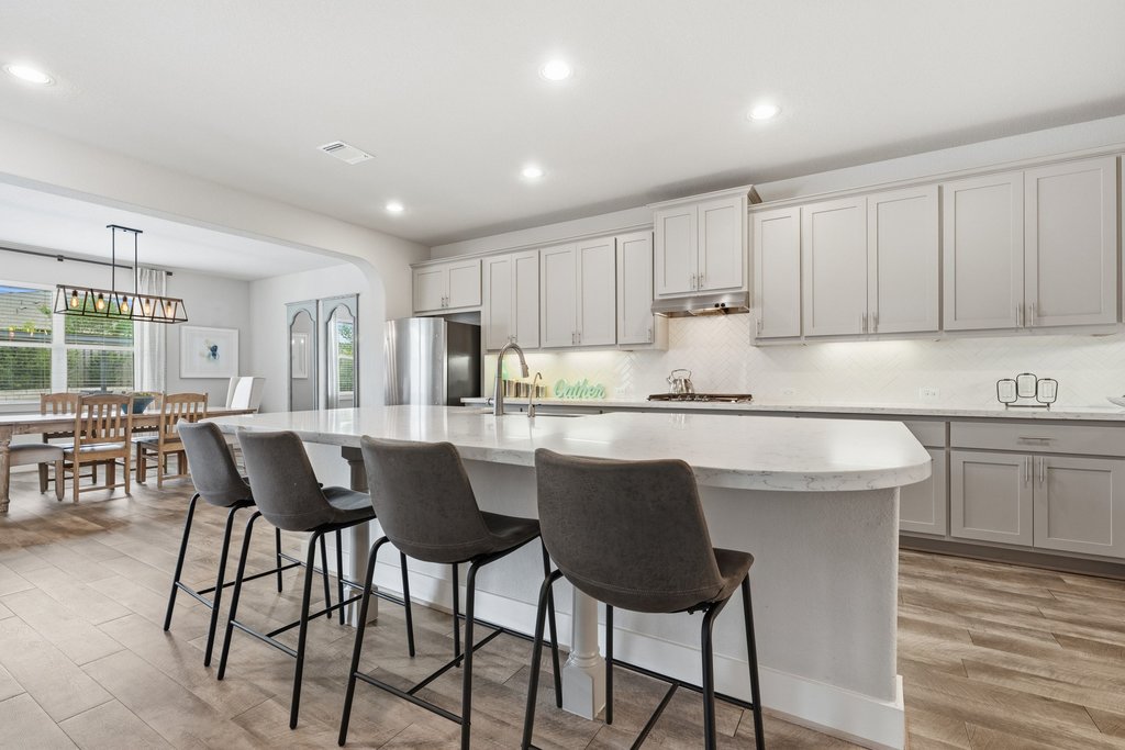 191 Tabago Court Austin, TX 78737 - Photo 9 of 40 a kitchen with a dining table chairs and white cabinets