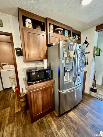 a kitchen with stainless steel appliances a refrigerator a stove a microwave and furniture