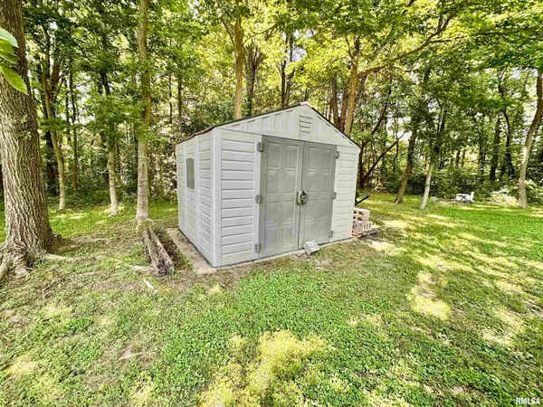 a view of a wooden chairs and table in the backyard